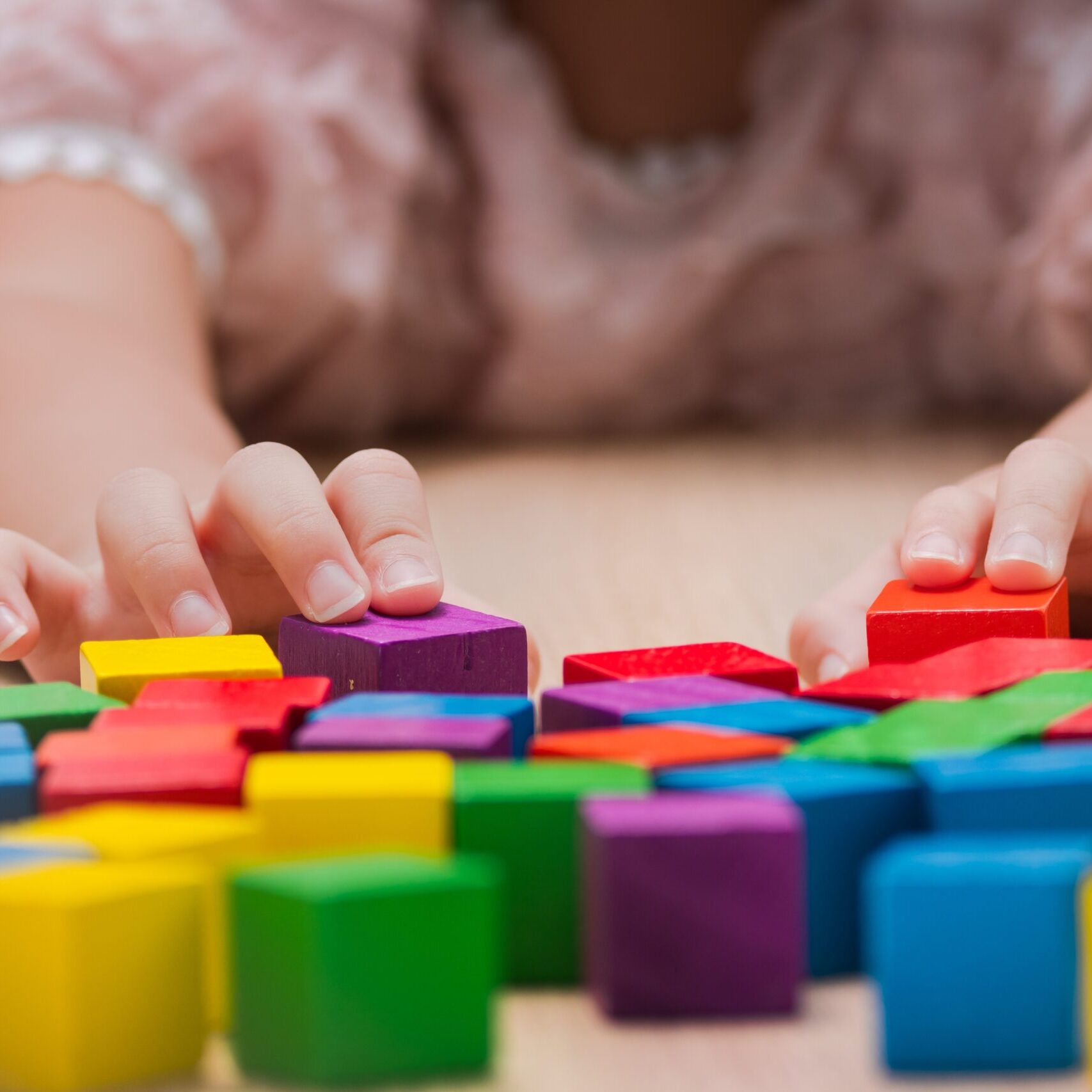 Closeup,Hand,Girl,Playing,Colorful,Wooden,Block,Toy,On,Table